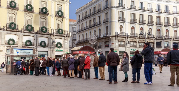 Una fila de personas ante la administración de lotería de la Puerta del Sol de Madrid. / Barcex. 