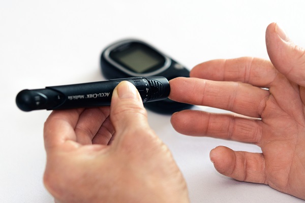 Una persona utilizando un glucómetro para medir sus niveles de glucosa. / PhotoMIX Ldt.