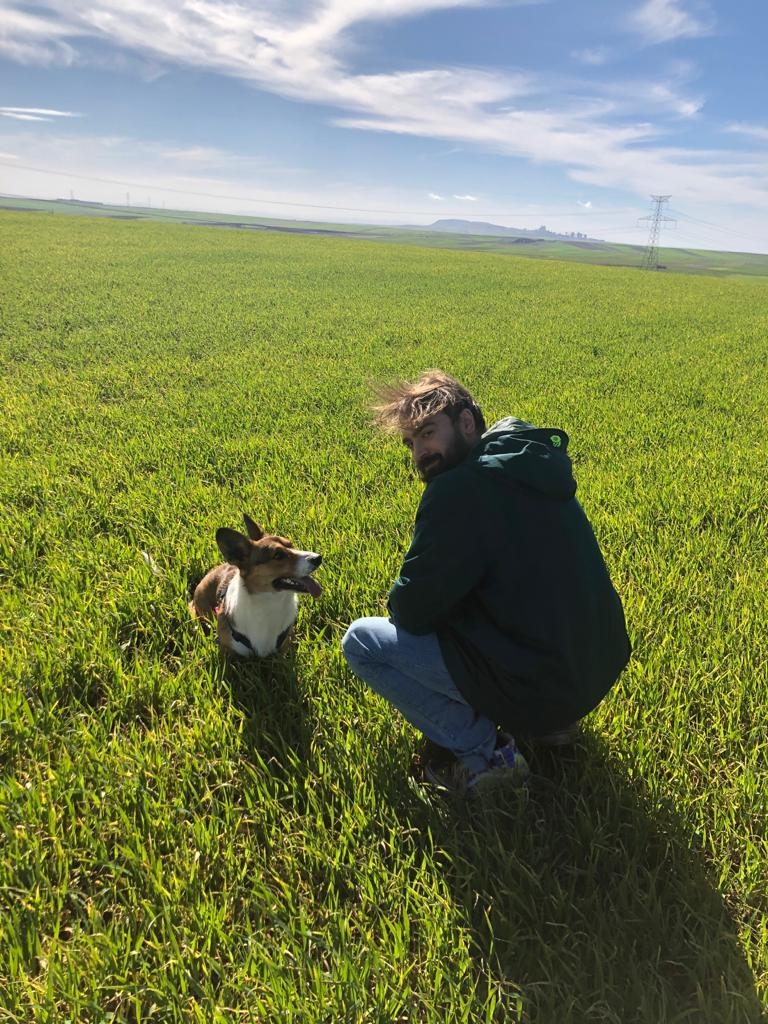 Israel Jiménez junto a su perro en los campos de Castilla-La Mancha
