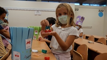 Una niña muestra su cereza en plastilina / María Marín.
